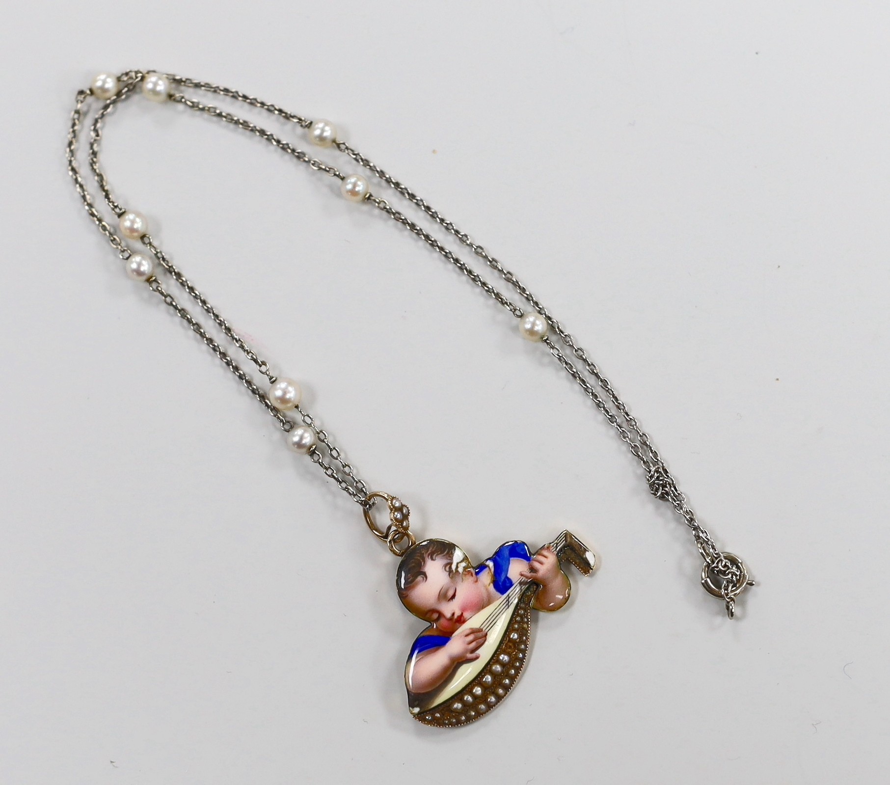 A continental yellow metal and enamel pendant, depicting a child with mandolin, 34mm, on a white metal and seed pearl chain, 38cm.
